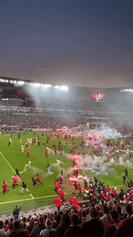 Kinh hoàng cảnh hỗn loạn trận derby: Hàng trăm CĐV lao xuống sân ném pháo sáng mù mịt, một thủ môn bị tấn công - Ảnh 1.